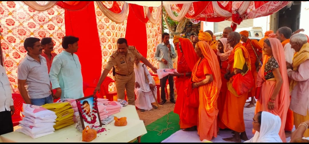 क़ुरावली के घनराजपुर मार्ग पर संतो को वस्त्र वितरित करते इंस्पेक्टर विनोद कुमार।